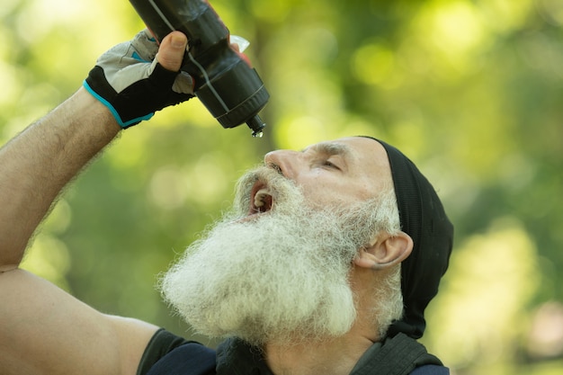 水のボトルとひげを生やした年配の男性