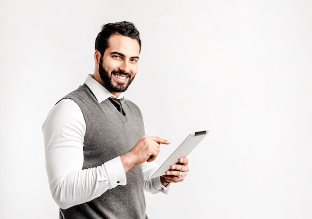 Бородатый улыбающийся бизнесмен держит планшетный компьютер
