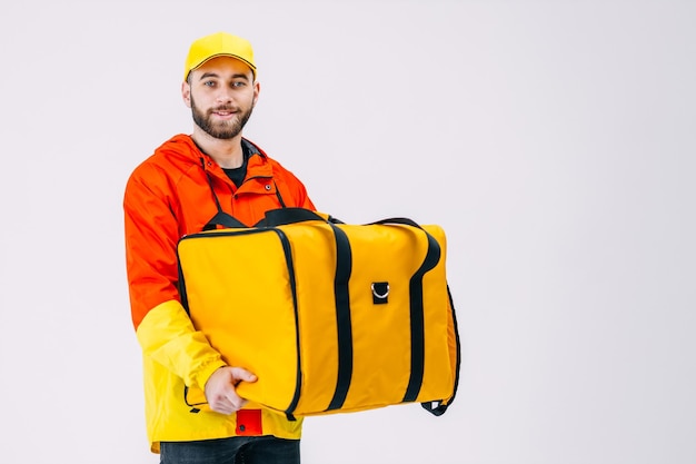 A bearded smiling man from a delivery service holding a backpack