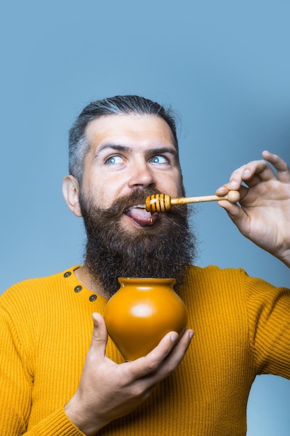 Bearded smiling man with honey jar