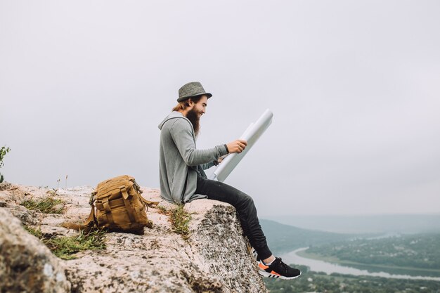 Bearded tourist looks at a map of area.