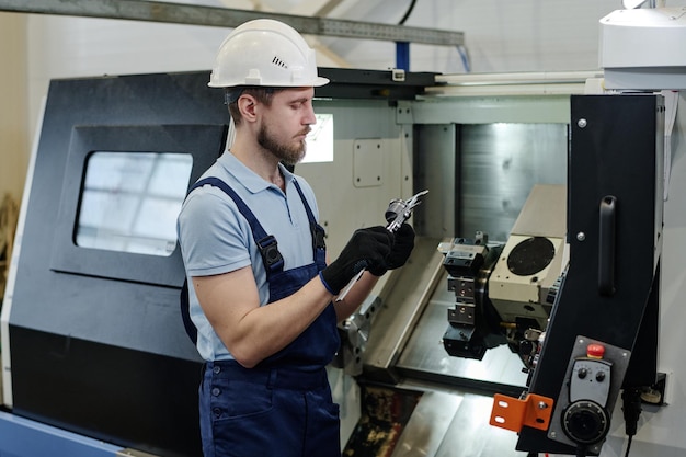 Bearded turner at work in factory