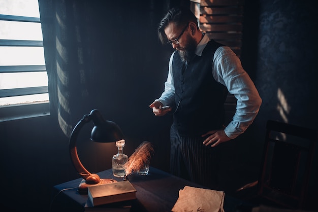 Bearded writer in glasses smoking a cigarette