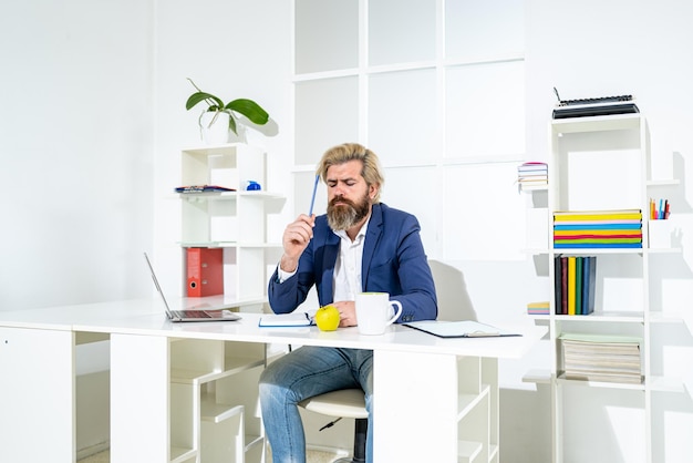 Bearded young businessman working at modern office Office worker making notes on the documents Elegant business man analyzing data in office