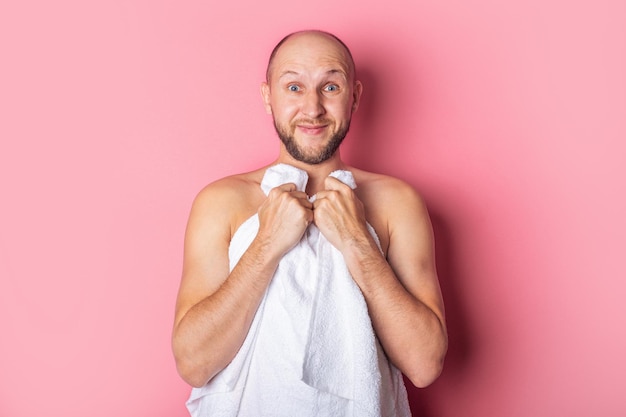 Photo bearded young nude man covered with towel on pink background