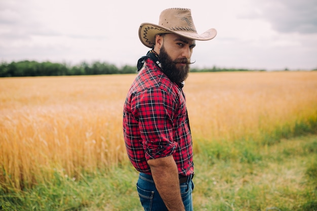 beared man with hat in a field modeling