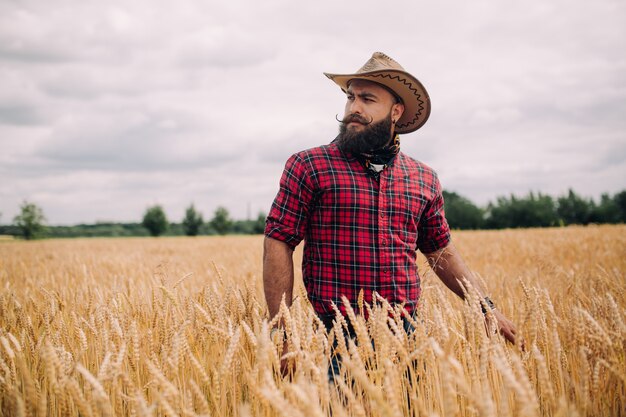 beared man with hat in a field modeling