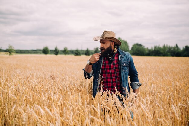 beared man with hat in a field modeling