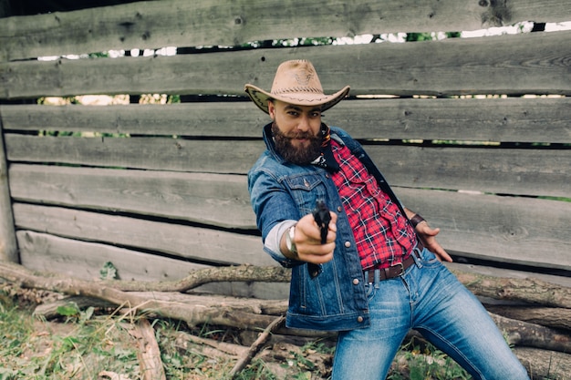 beared man with hat and a gun