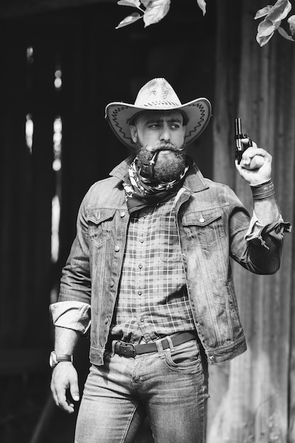 Photo beared man with hat and a gun