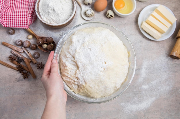 Sbattere la farina e gli utensili da cucina una teglia un mattarello con le uova sul tavolo concetto di cottura al forno chef che prepara pane e biscotti di pan di zenzero il cuoco impasta e arrotola la pasta