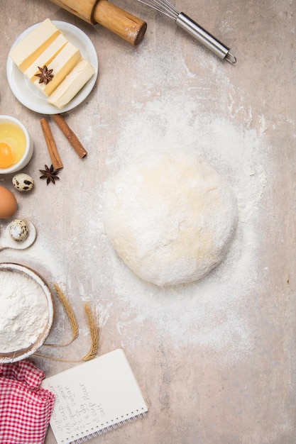 Beat flour and kitchen utensils a baking dish a rolling pin with eggs on the table Baking cooking concept Chef making bread and gingerbread cookies The cook kneads and rolls the dough