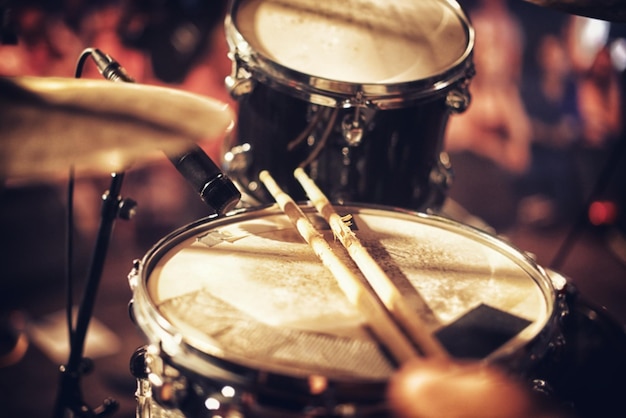 A beat waiting to happen Drum kit set up on a stage with a crowd in the background