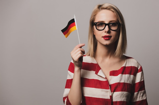 Beatiful girl in glasses holds German flag