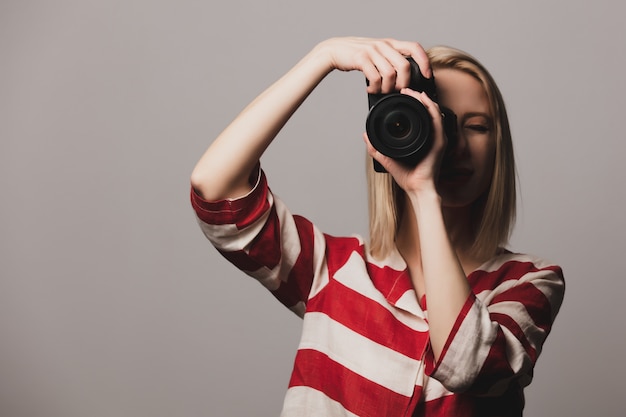 美しい少女の手で写真カメラを保持します