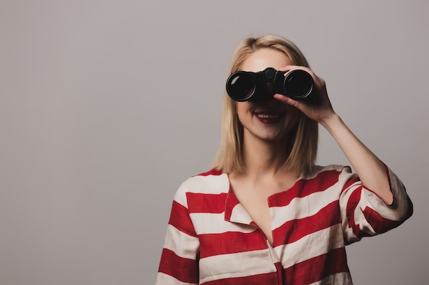 Beatiful girl in jacket holds binoculars