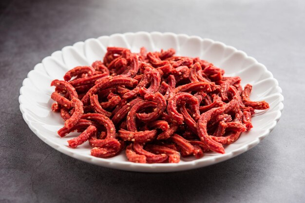 Photo beatroot chakli sticks made using beetroot fried tea time snack from india