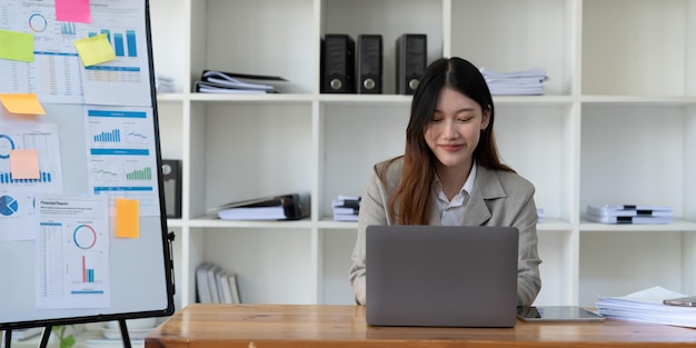 Beauitul young business asian woman working using computer laptop concentrated and smiling