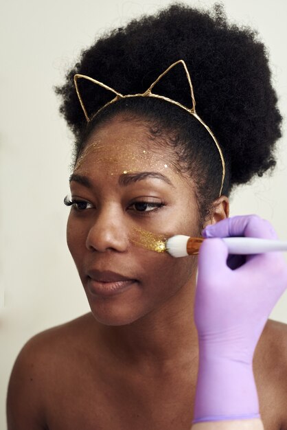 The beautician applies a moisturizing mask to the client's face.