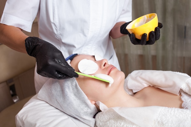 The beautician apply an alginite mask on client