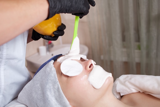 The beautician apply an alginite mask on client