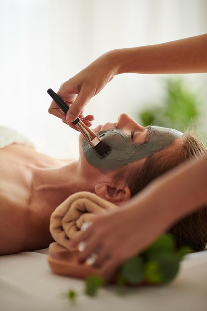 Beautician Applying Black Clay Mask