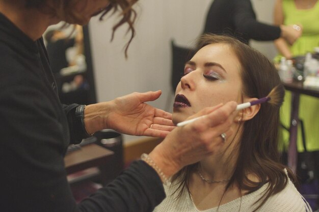 Photo beautician applying make-up to woman