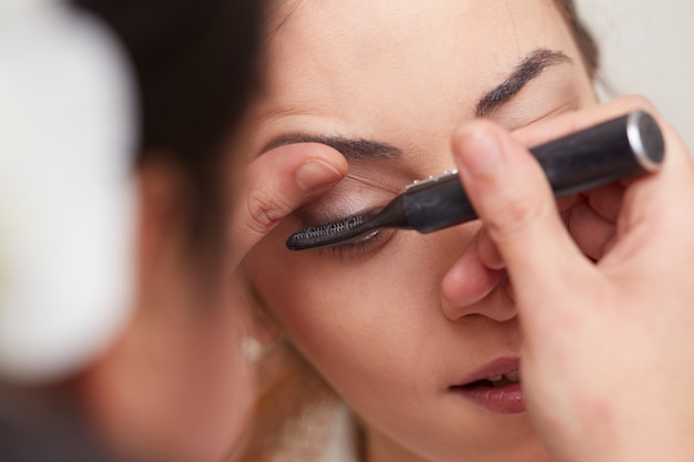 Beautician applying make up