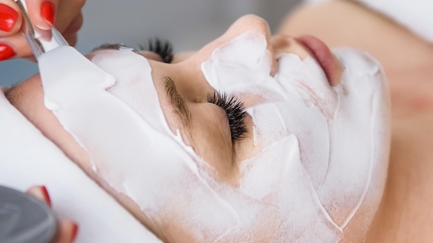 Estetista cosmetologo che applica maschera di bellezza peeling viso salone termale