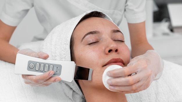 Beautician doing face beauty routine for female client