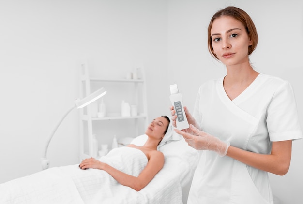 Photo beautician doing face beauty routine for female client