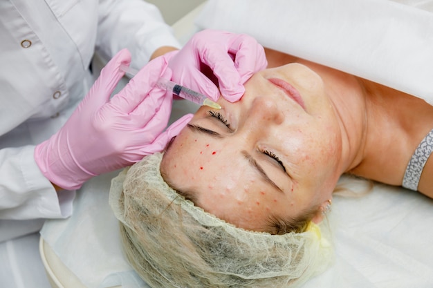 Beautician doing facial injection. Anti-aging revitalization cosmetology procedure