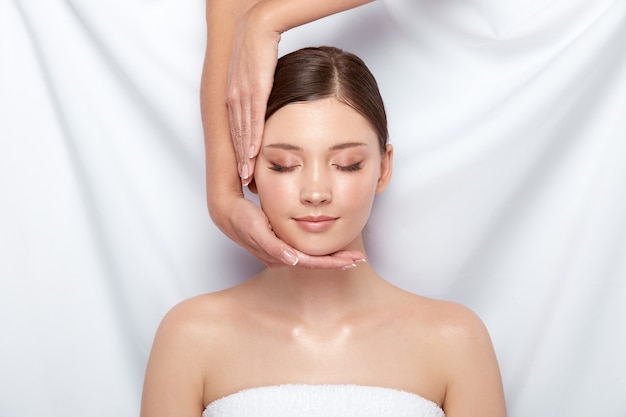 Beautician doing facial massage for female customer