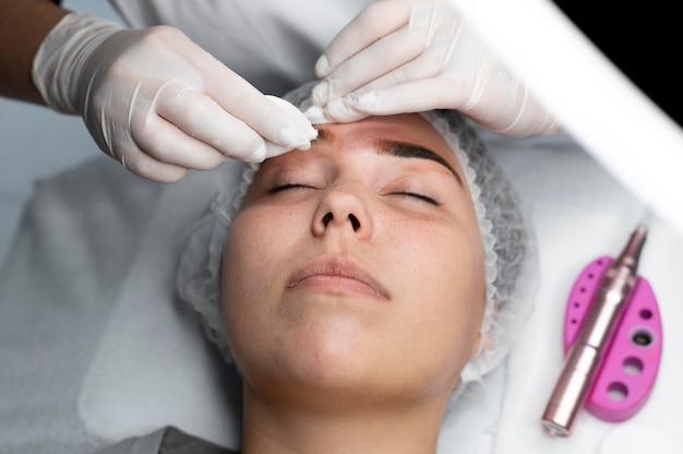 Foto estetista che esegue una procedura di microblading su una donna