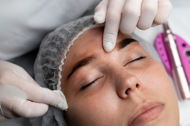 Estetista che esegue una procedura di microblading su una donna