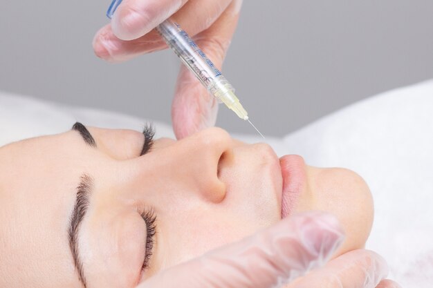 Beautician Injecting collagen in lips