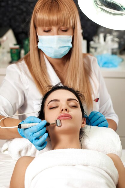 Beautician makes cleaning of face in spa salon