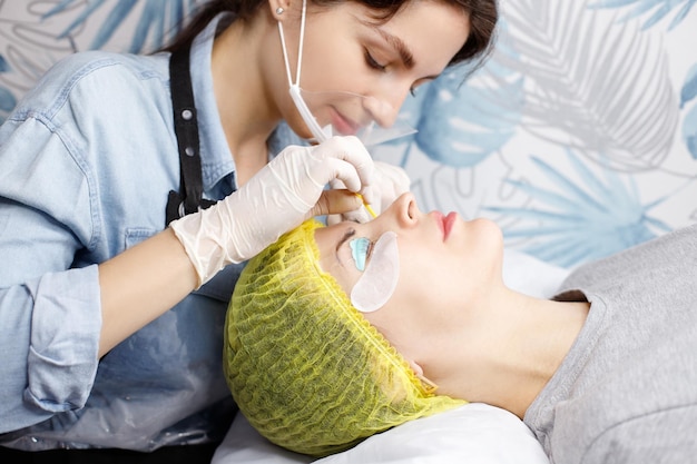 Beautician makes lamination of eyelashes in the salon