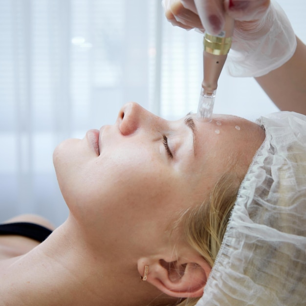 Фото Косметолог делает инъекции мезотерапии спа-салон красоты уход за кожей женщина получает уход за лицом от косметолога в спа-салоне, вид сбоку оздоровительный центр занятие здравоохранением
