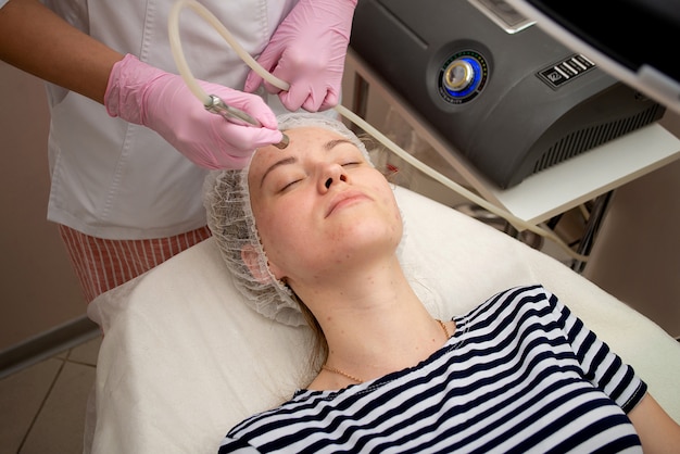 Beautician makes procedures on woman's face