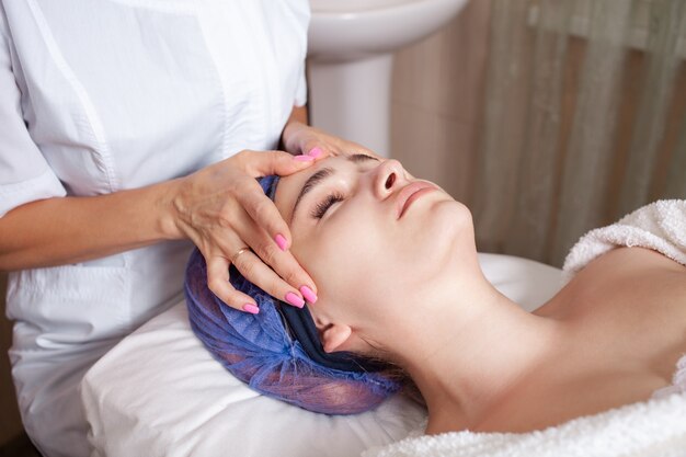 beautician massages the face of client