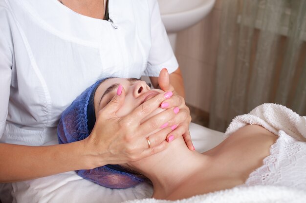 beautician massages the face of client