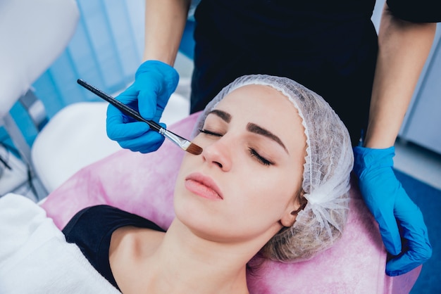 Beautician and the patient in the clinic of aesthetic medicine receiving a treatment