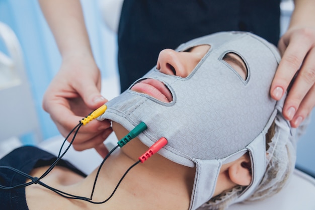 Beautician and the patient in the clinic of aesthetic medicine receiving a treatment