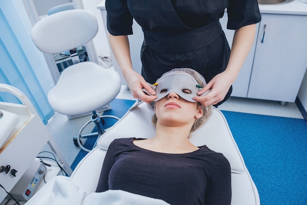 Beautician and the patient in the clinic of aesthetic medicine receiving a treatment