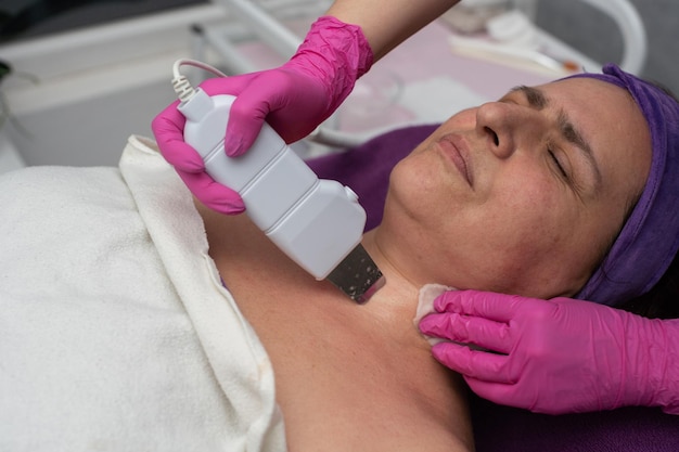 The beautician performs cavitation peeling using an ultrasound device