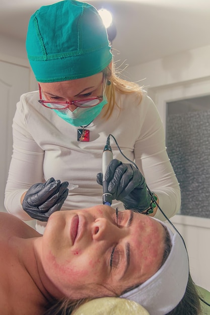 Beautician performs a needle mesotherapy treatment on a woman face.