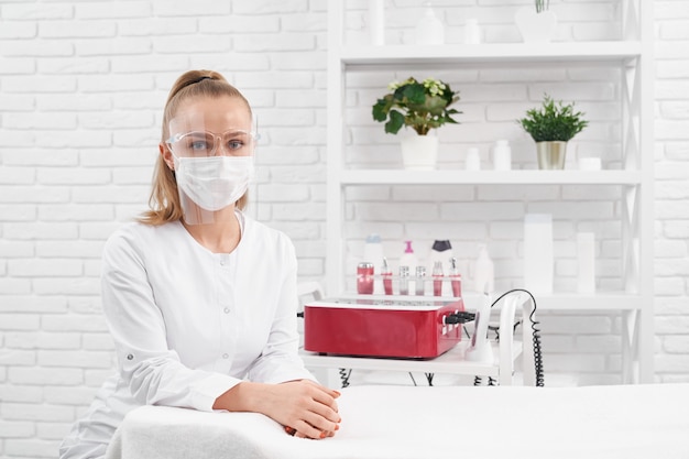 Beautician in protective mask waiting for clients