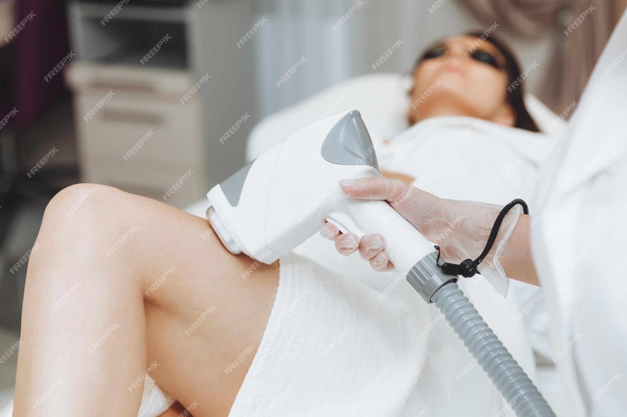 Premium Photo | Beautician removes hair on female legs with a laser hair  removal on legs laser hair removal in the salon