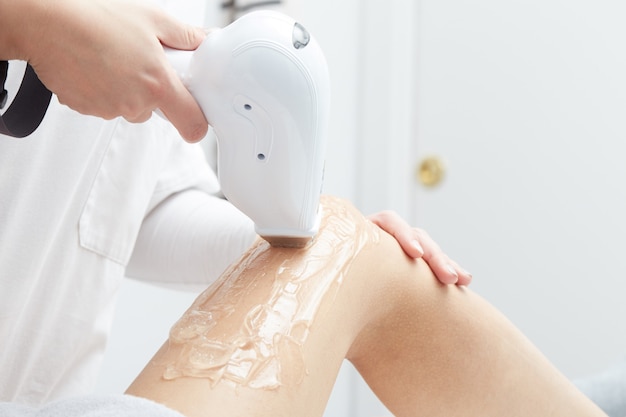 Beautician Removing Hair Of Young Woman with laser